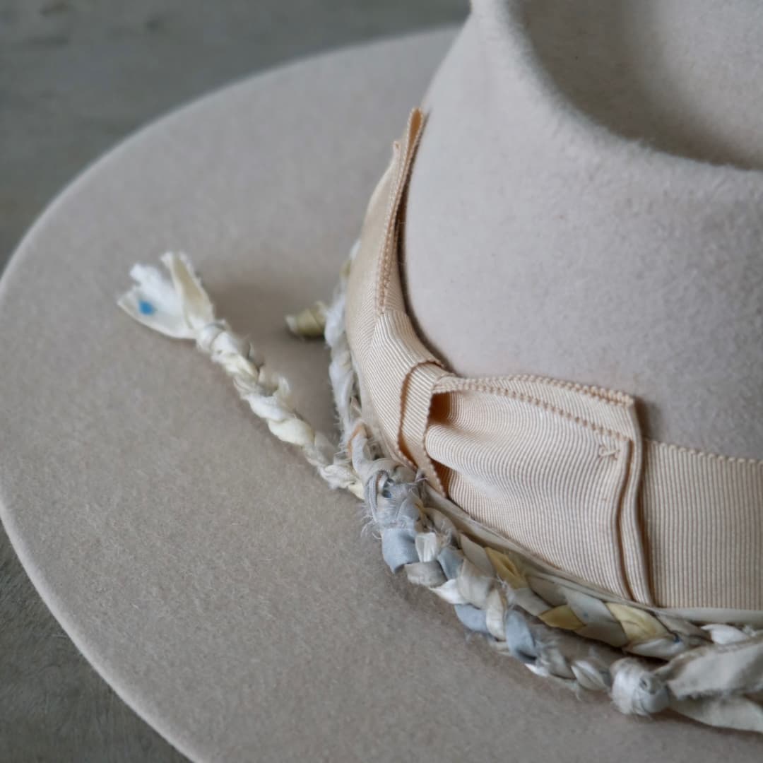 Close up detail of the Shoalhaven felt hat showing the plaited sari silk trim in sand, stone and soft green.