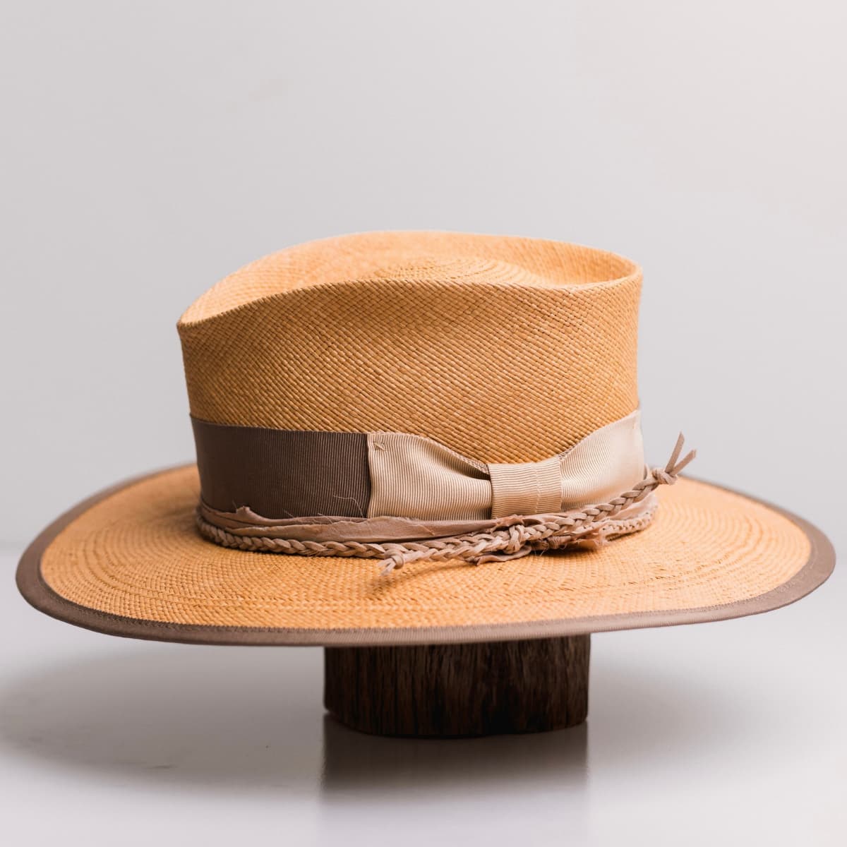 Left side view of the Taupetone Biscuit Panama hat by PHYLLi Designs with taupe Japanese grosgrain band, sand bow and plaited nude suede string.