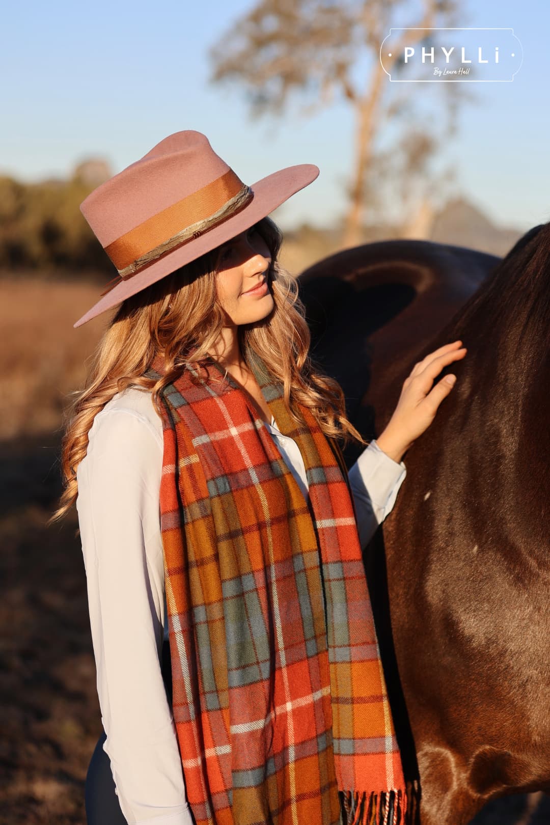 Woman smiling beside horse wearing The Blush felt hat by PHYLLi Designs.