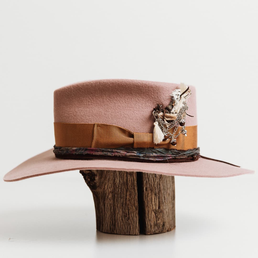 Left side view of The Blush felt hat by PHYLLi Designs with chunky hat pin and sari silk trim.