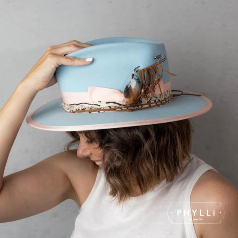 Brunette model wearing The Cyan felt hat by PHYLLi Designs with sherbet pink grosgrain band and silver chunky hat pin.