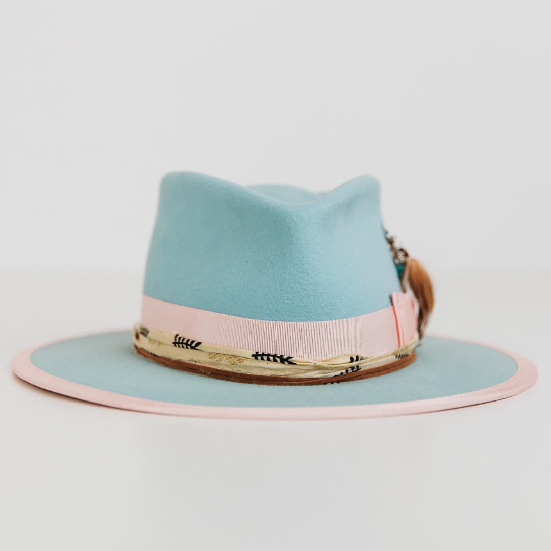 Front view of The Cyan felt hat by PHYLLi Designs in cyan with sherbet pink grosgrain band, pink brim trim and cream and black sari silk trimming.