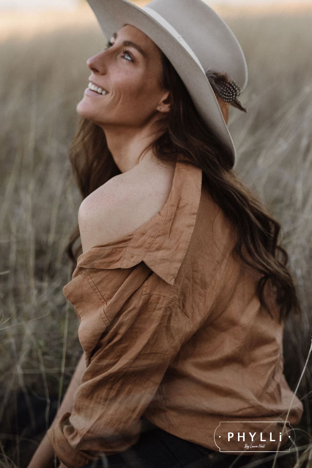 Woman wearing The Dartbrook beige felt hat with feather detail by PHYLLi Designs.