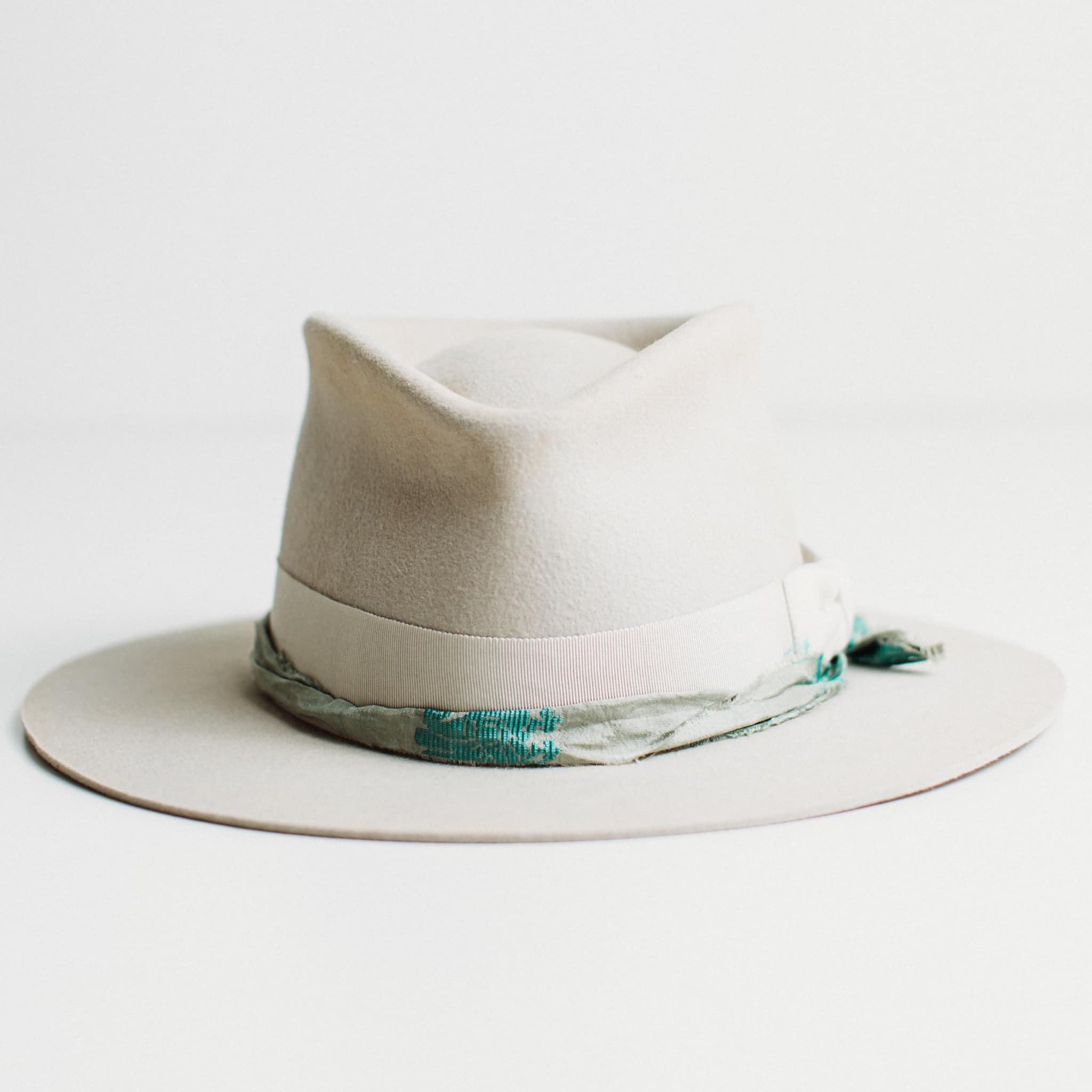 The Dove dove-coloured felt hat with Japanese grosgrain band, ivory velvet bow and blue teal sari silk trim by PHYLLi Designs.