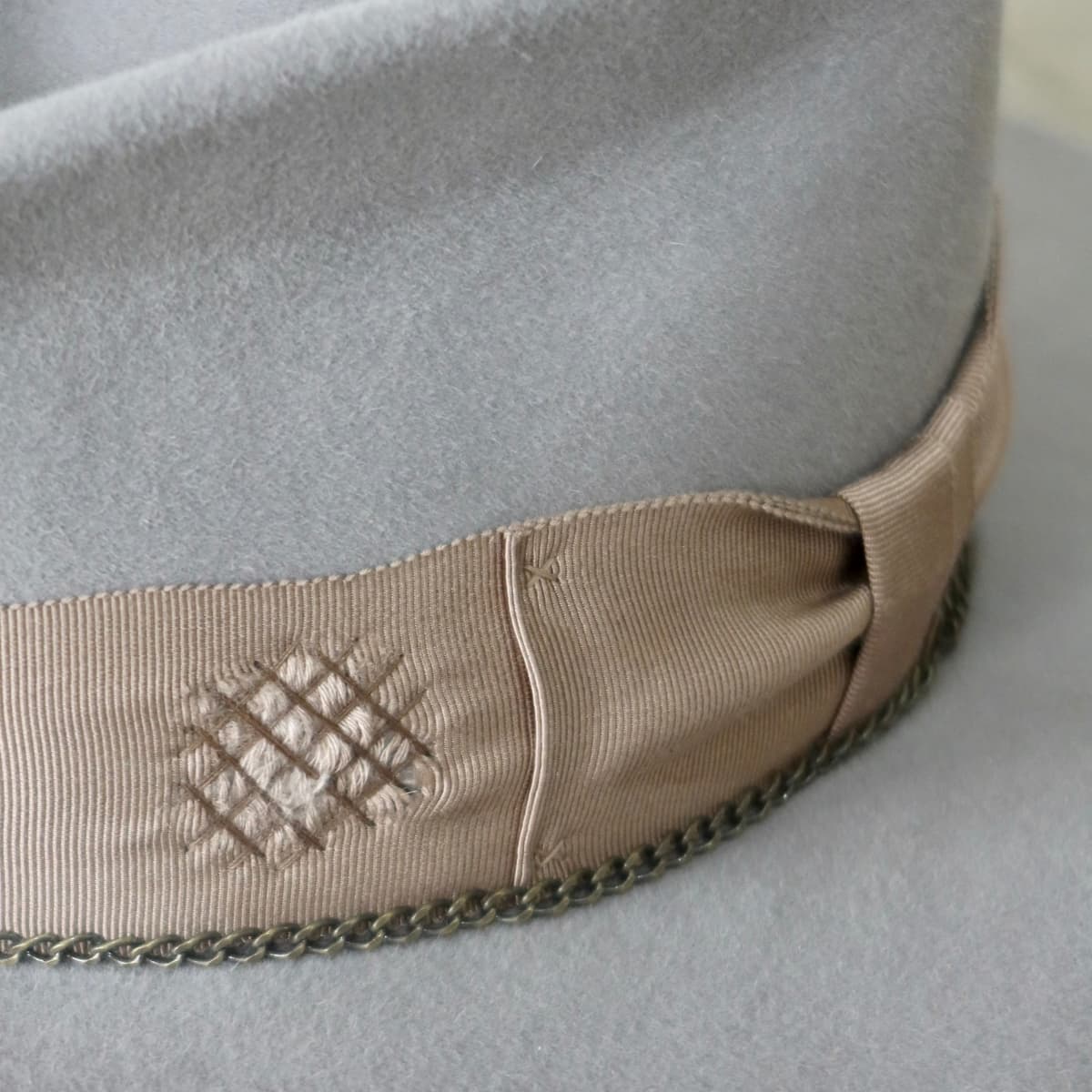 Close up of hand-darned distressed patch on Drifter taupe felt hat by PHYLLi Designs.
