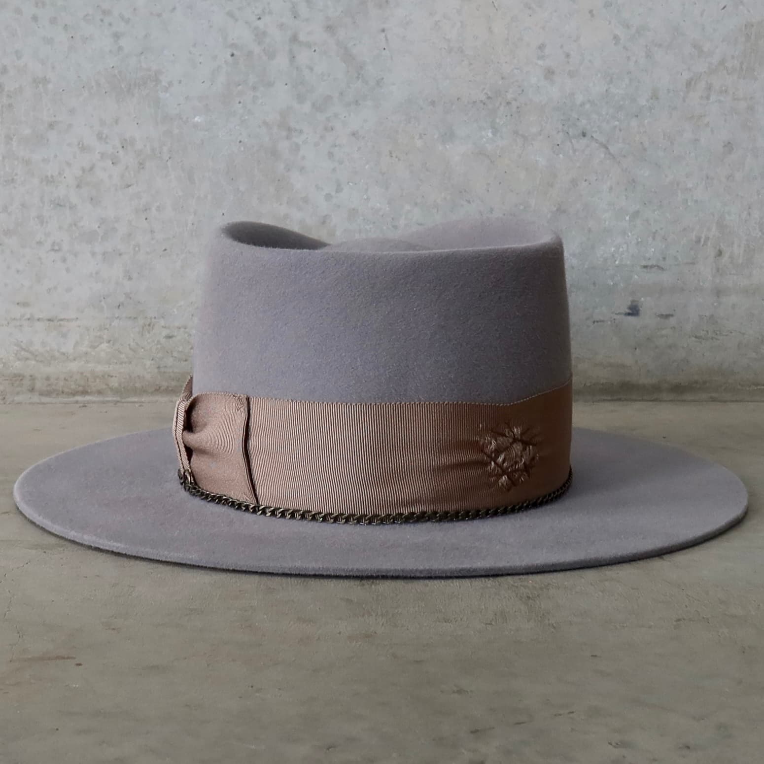 Back view of Drifter felt hat by PHYLLi Designs with distressed grosgrain band and crown chain.
