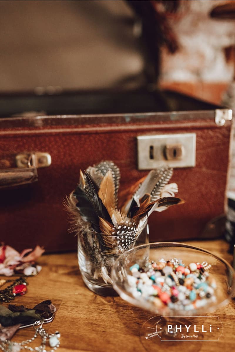 Feathers, charms and trims displayed for guests to personalise hats at a PHYLLi hat party event.