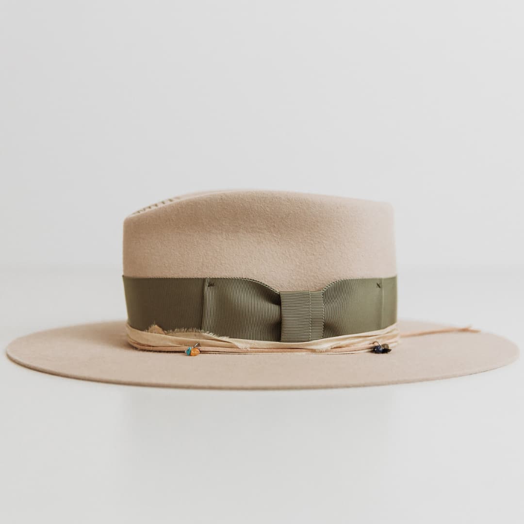 Left side view of The Guardian beige felt hat featuring sari silk trim and crystal charms.