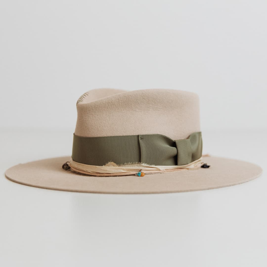 Front left angle of The Guardian felt hat by PHYLLi Designs with oil green grosgrain bow band and suede string.