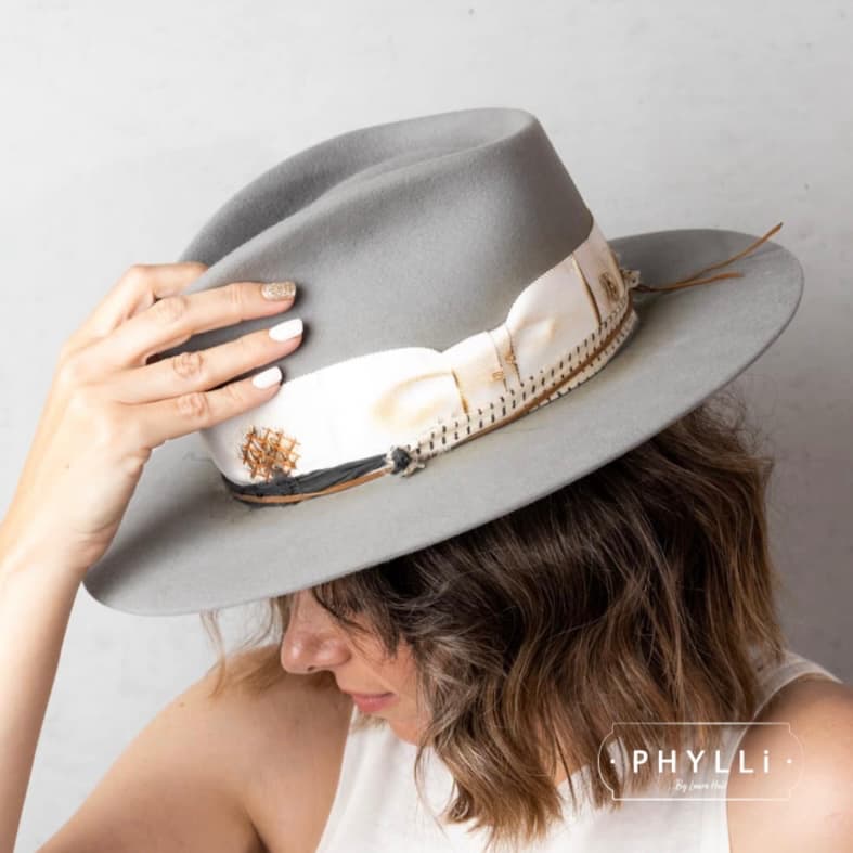 Woman wearing The Paver taupe felt hat by PHYLLi Designs with distressed ivory grosgrain band and sari silk trim.