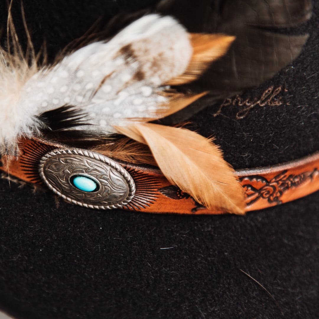 Close up detail of The PHYLLi felt hat showing Buffalo Girl Rugged Desert tie back leather band with hand-burnt pattern.