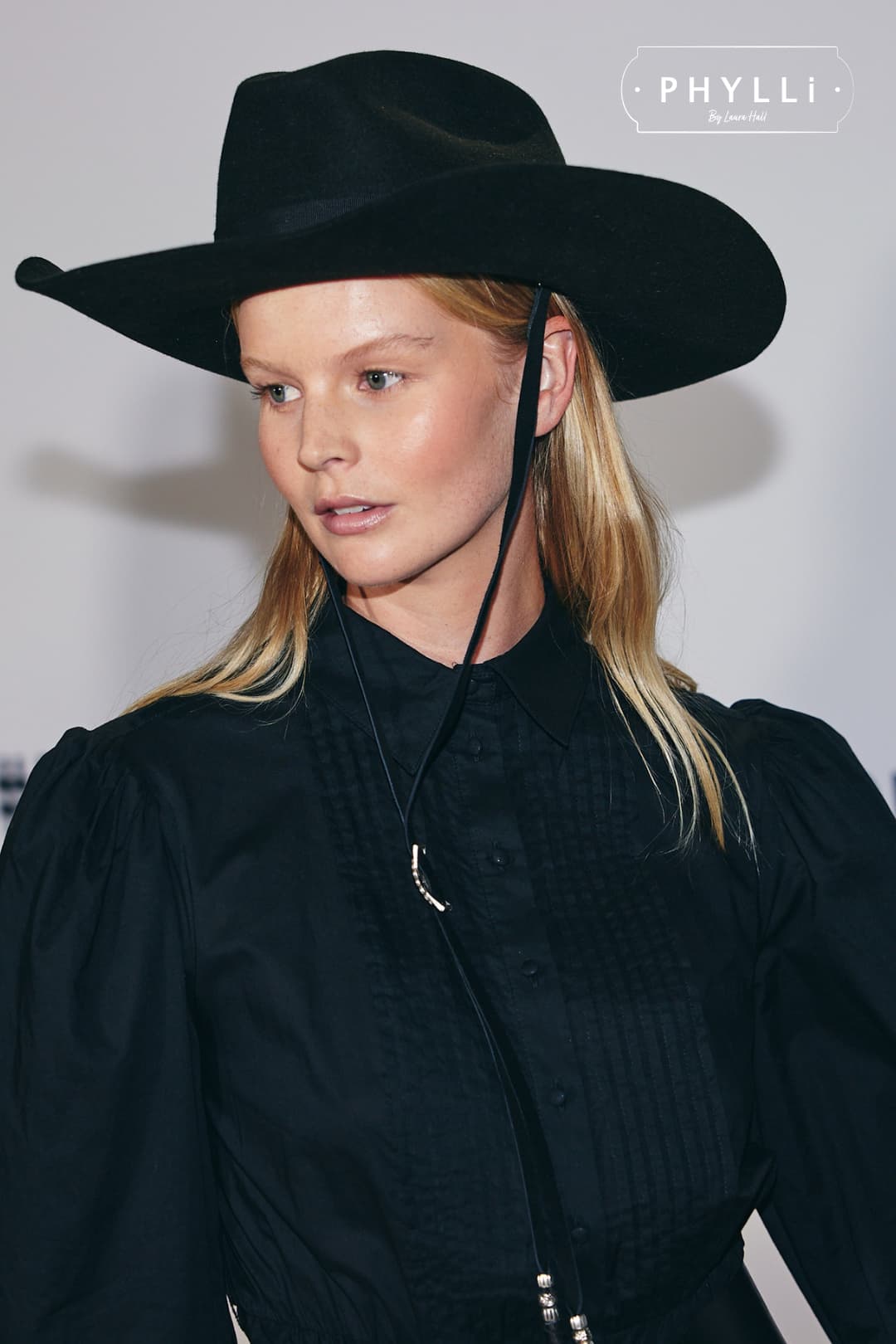 Woman wearing The Plains black felt cowboy hat by PHYLLi Designs with black Japanese grosgrain bow band.