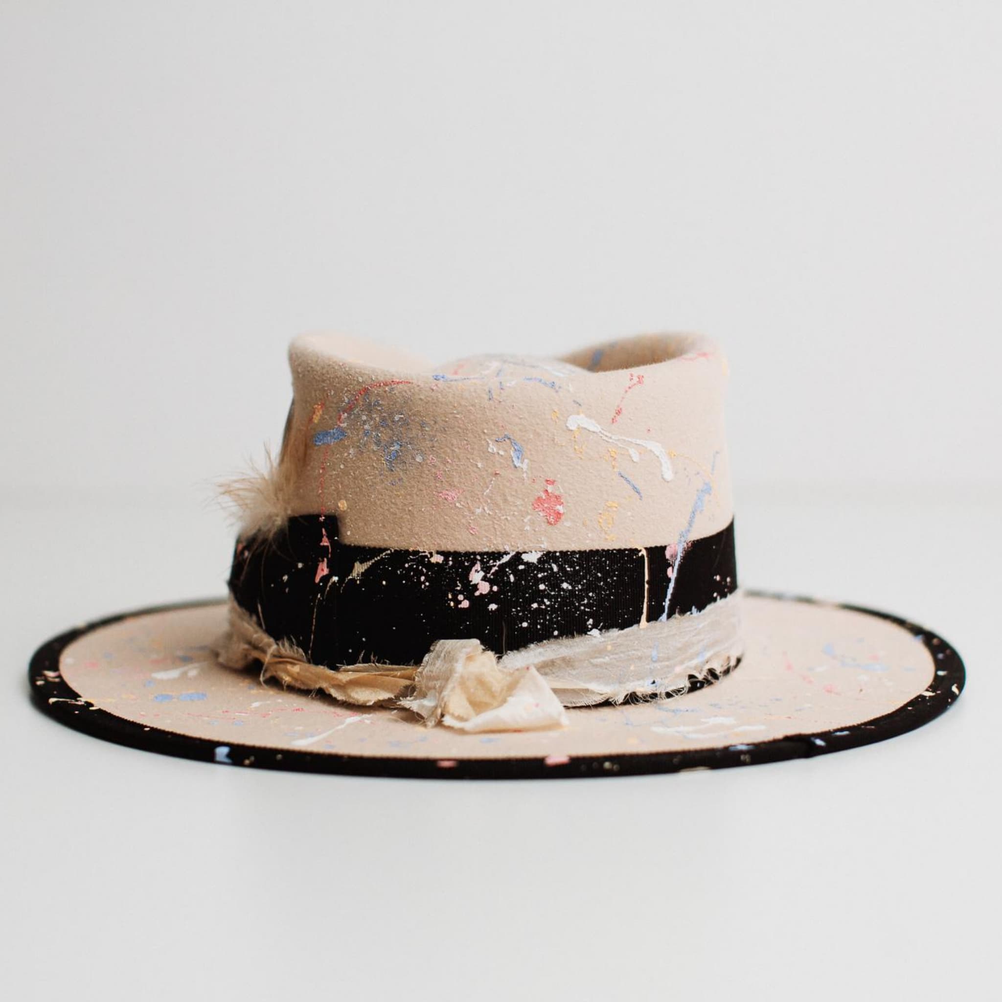 Back view of Pollock beige felt hat by PHYLLi Designs showing paint splatter detail and black grosgrain band.