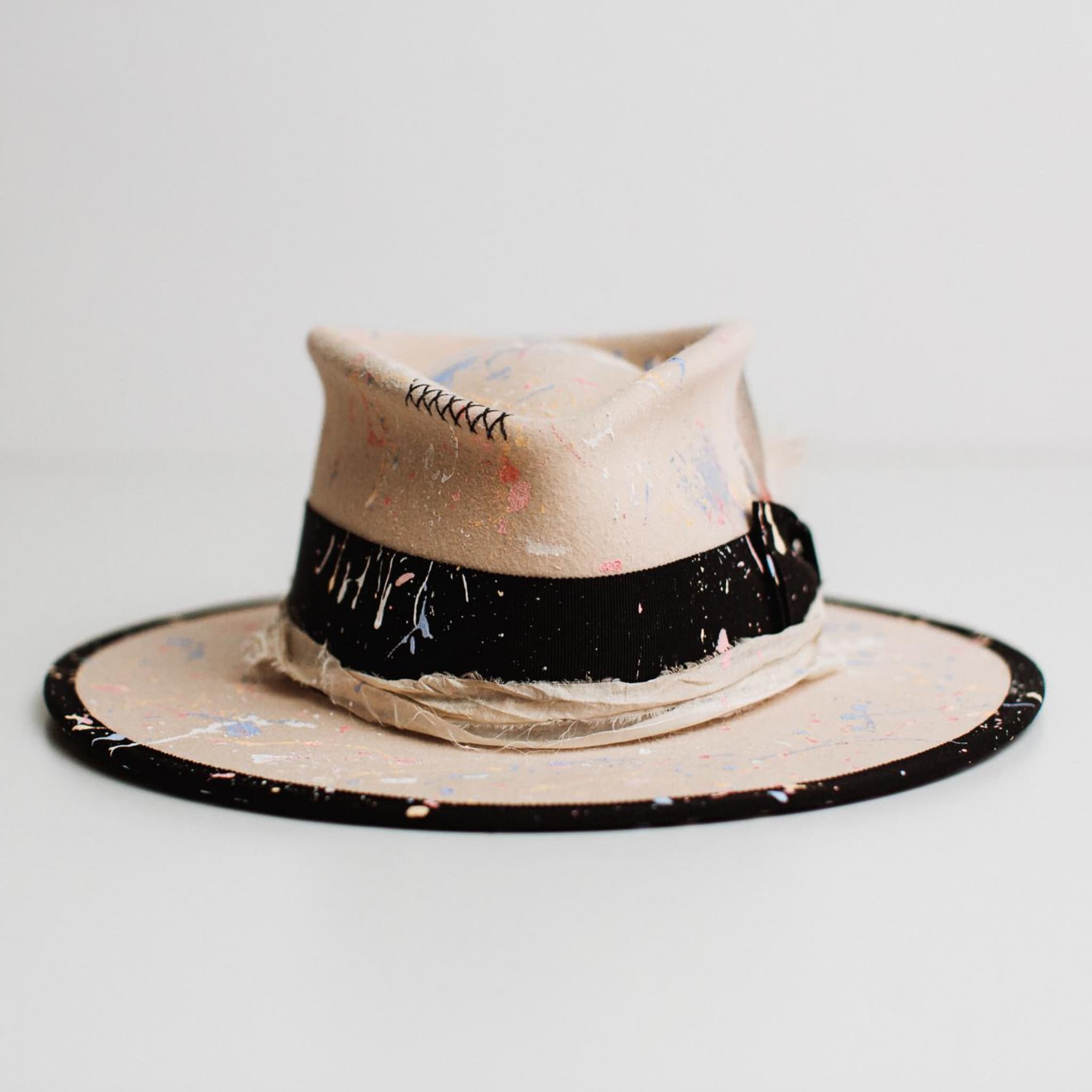 Front view of Pollock beige felt hat by PHYLLi Designs with paint splatter detail and black grosgrain band.