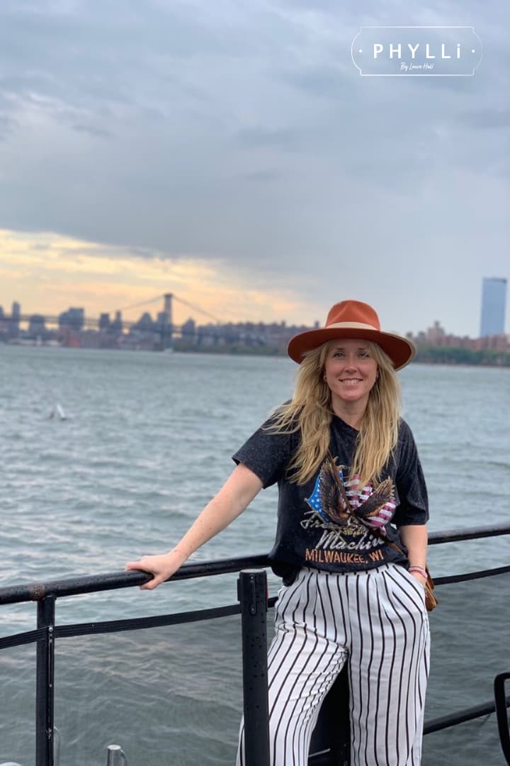 Lifestyle image of a woman by the waterfront with city skyline wearing the spiced pumpkin Producer felt hat.
