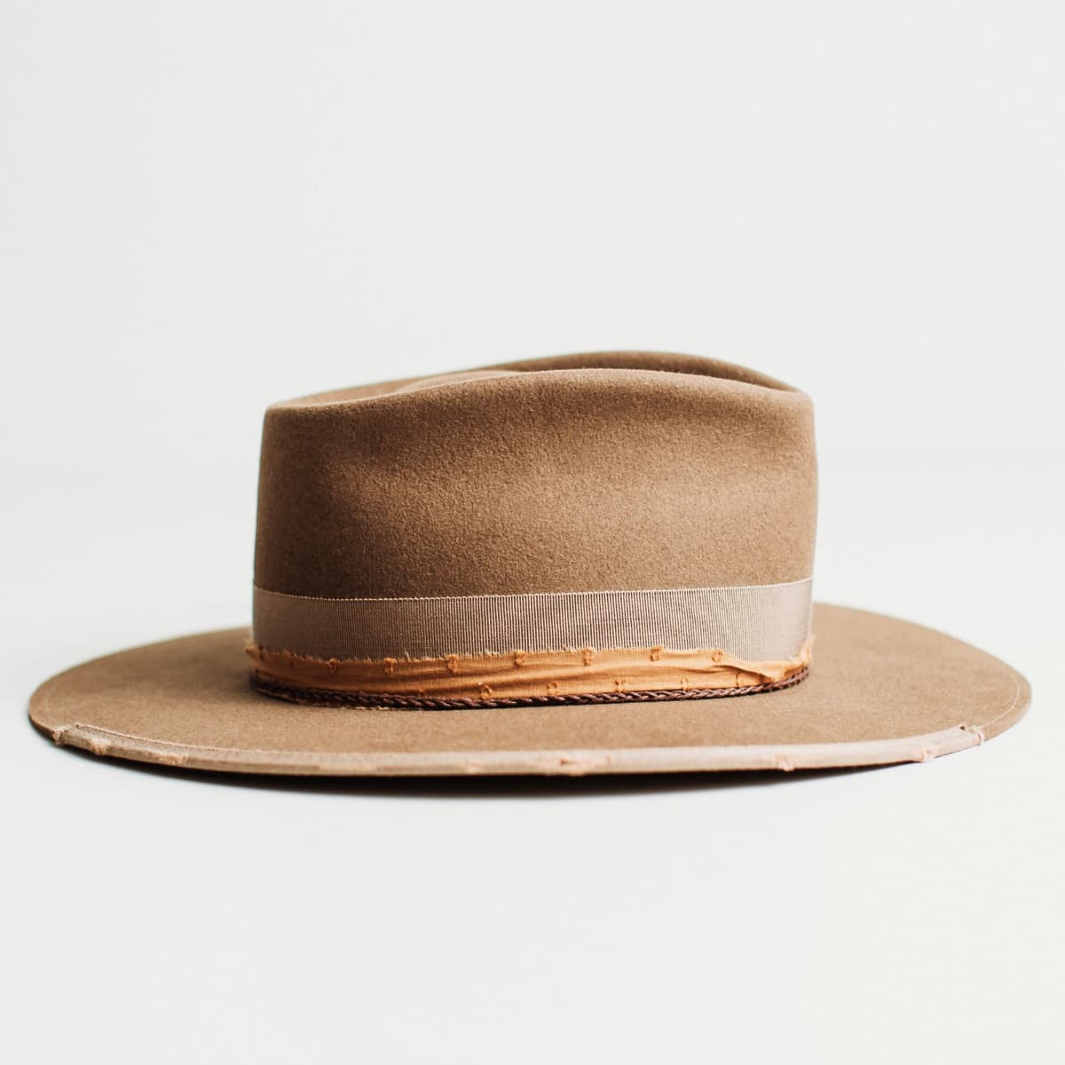 Right side view of havana brown felt hat with grosgrain bow band and feather accent.