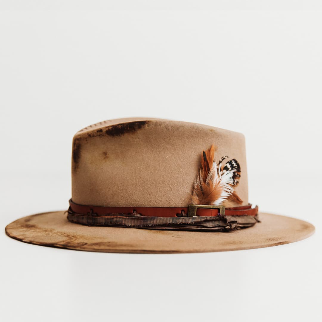 Left side profile of The Safari hat by PHYLLi Designs in distressed Sahara felt with antique leather belt trim.