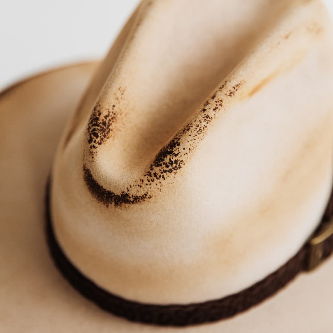 Close up detail of distressed beige felt on The Wheeler hat.