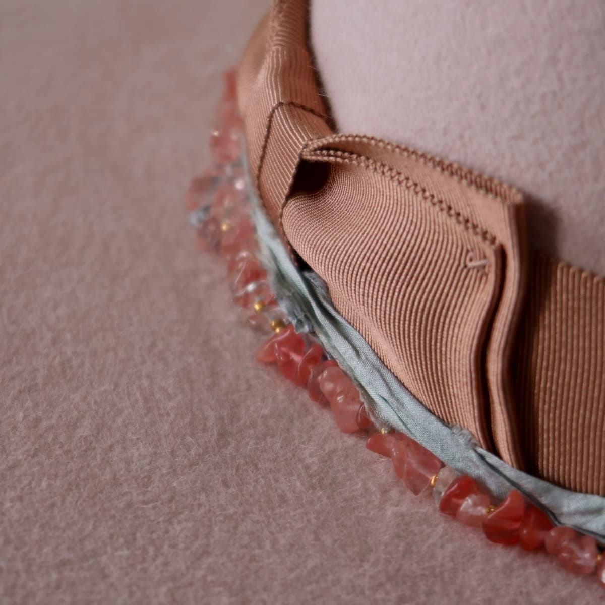 Close up detail of the Tourmaline felt hat showing dirty rose Japanese grosgrain double bow stitching.