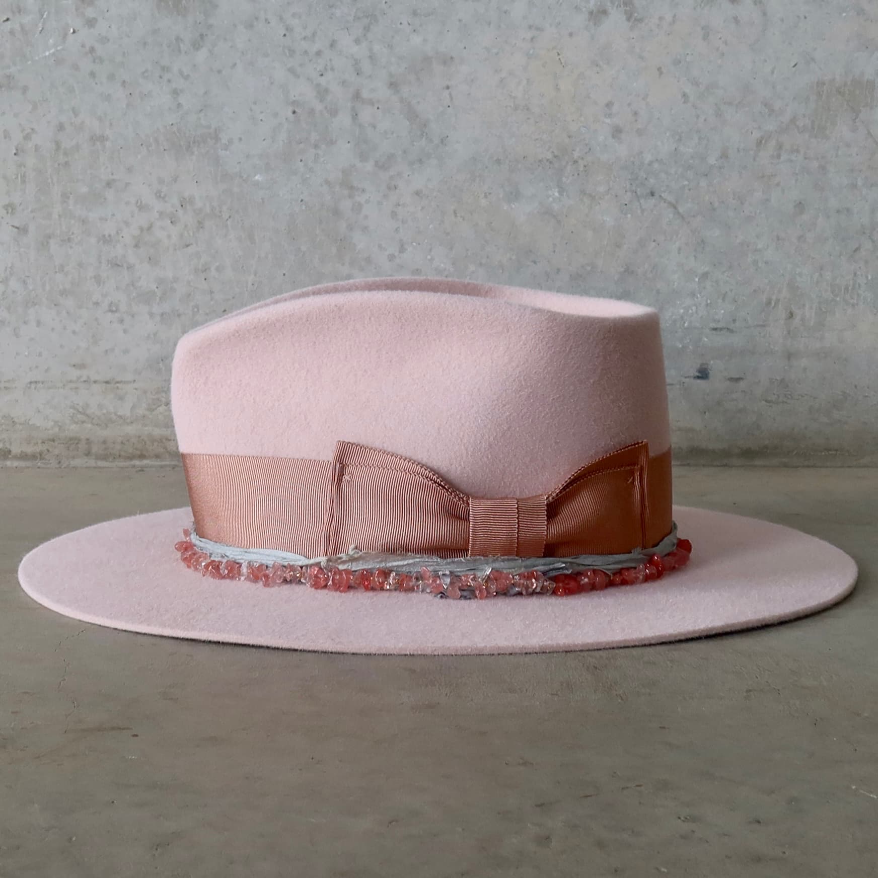Left side view of the Tourmaline Baby Pink felt hat by PHYLLi Designs with rose quartz hat necklace and ocean sari silk trim.