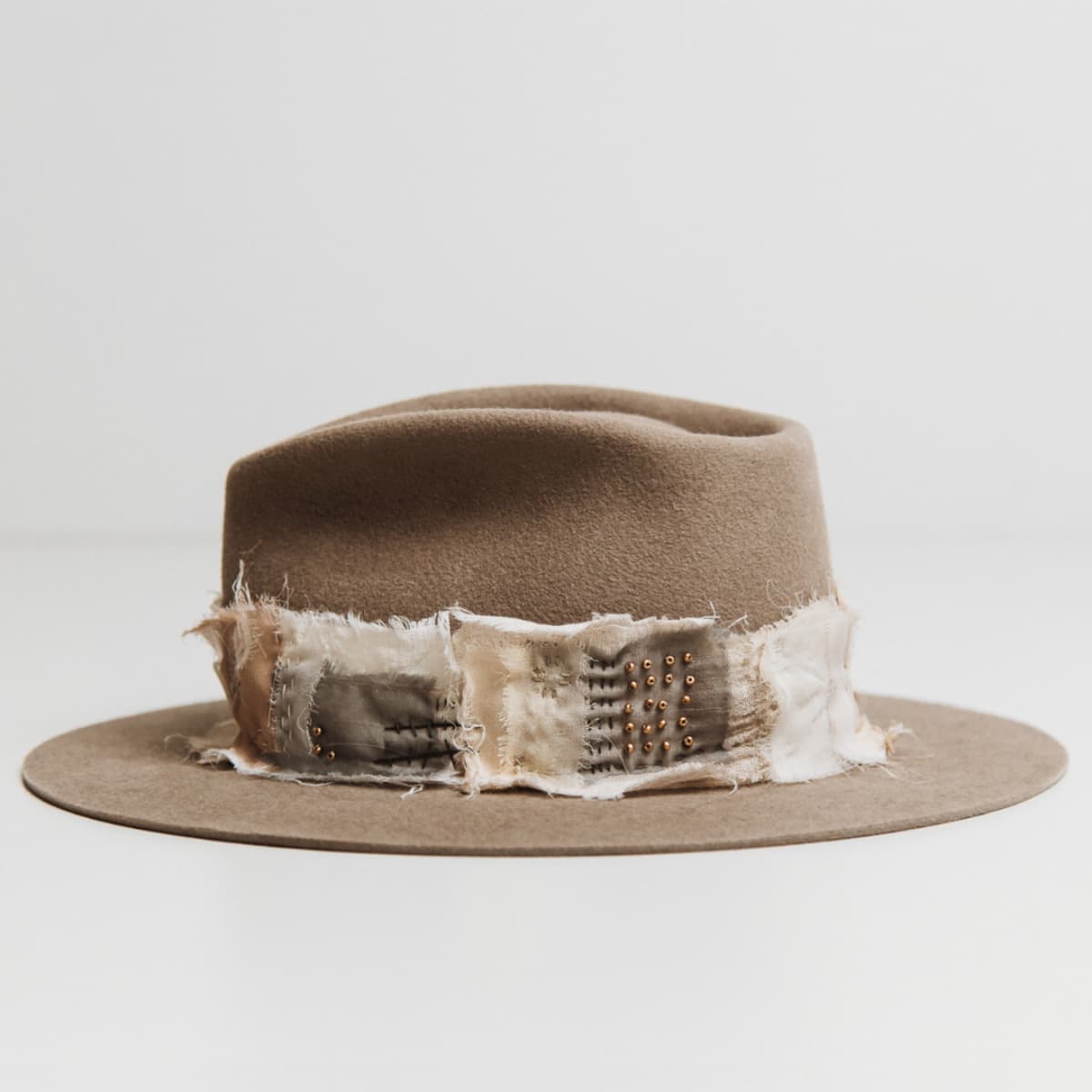 Left side view of the Wabi Limited Edition Sahara felt hat by PHYLLi Designs with sashiko stitched patch band and matte gold bead accents.