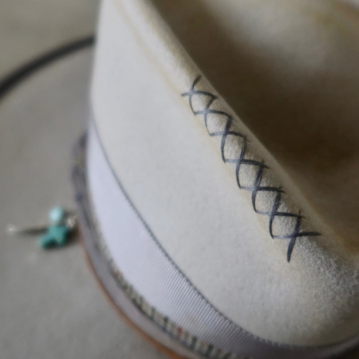 Close up detail of the Watson Limited Edition felt hat showing hand stitched crosses in charcoal on the felt crown.