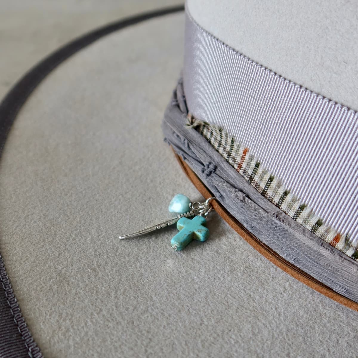 Close up detail of the Watson Limited Edition felt hat showing turquoise beading and silver feather charm cluster.