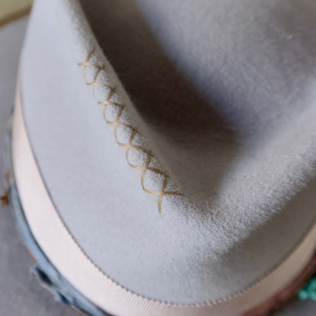 Close up detail of the Wolseley felt hat showing hand stitched taupe cross detailing on the crown.