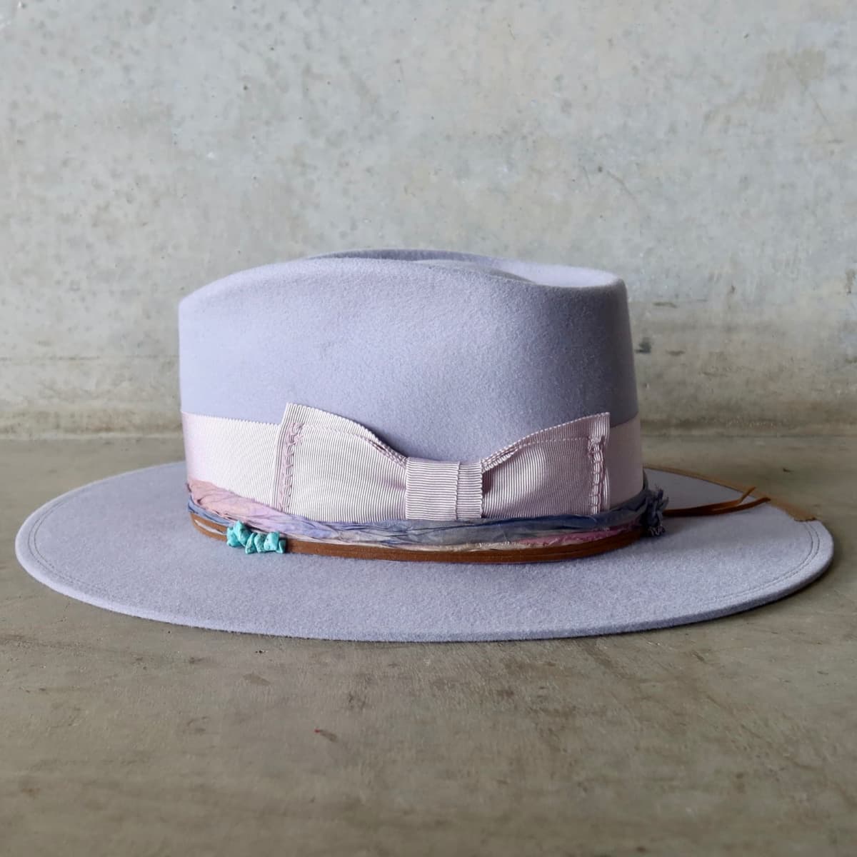 Left side view of the Lilac felt hat Wolseley by PHYLLi Designs with lilac grosgrain bow band and taupe brim trim.