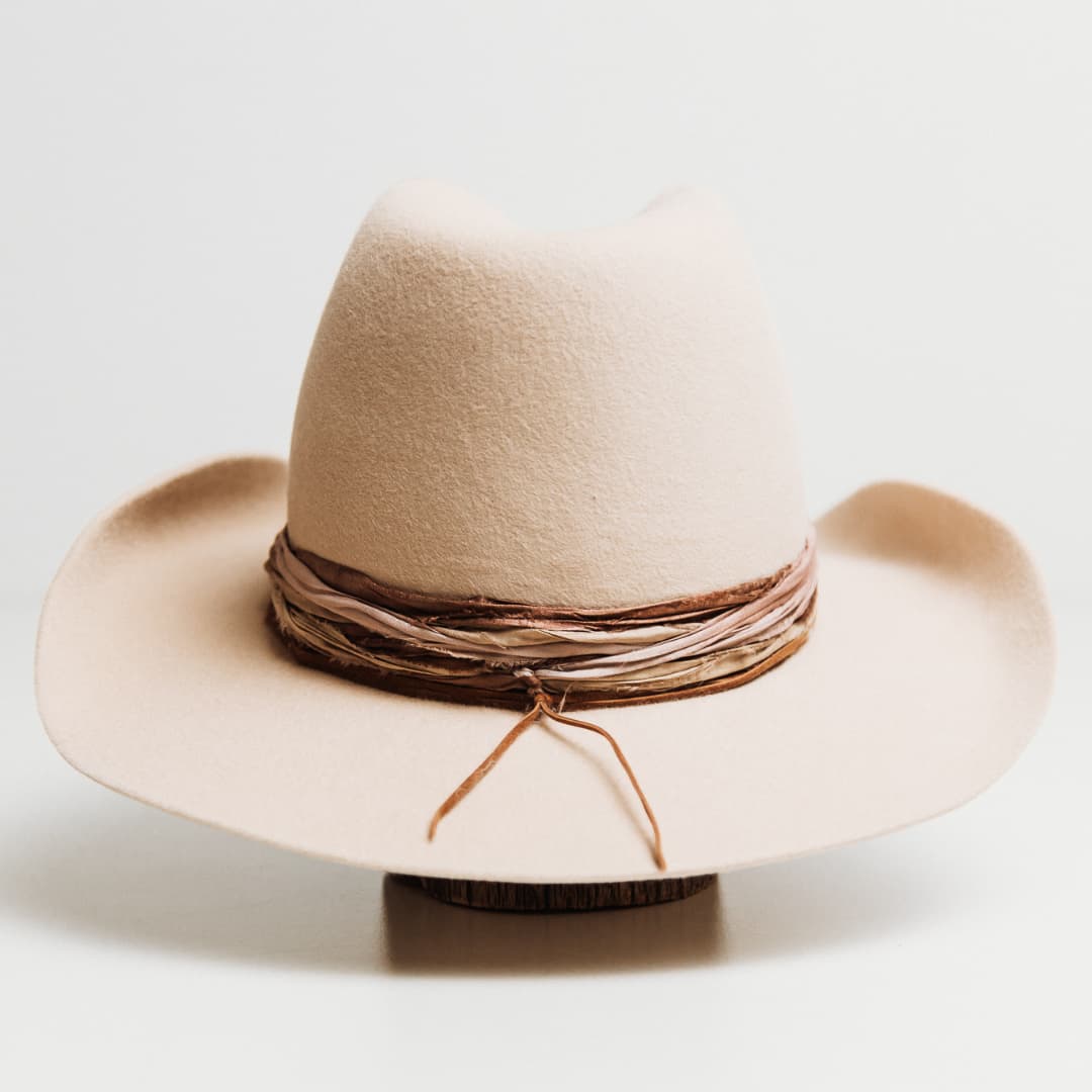 Back view of the Wrapped Wheeler beige felt hat by PHYLLi Designs featuring dusty pink and nude tie dye sari silk wrapped band.