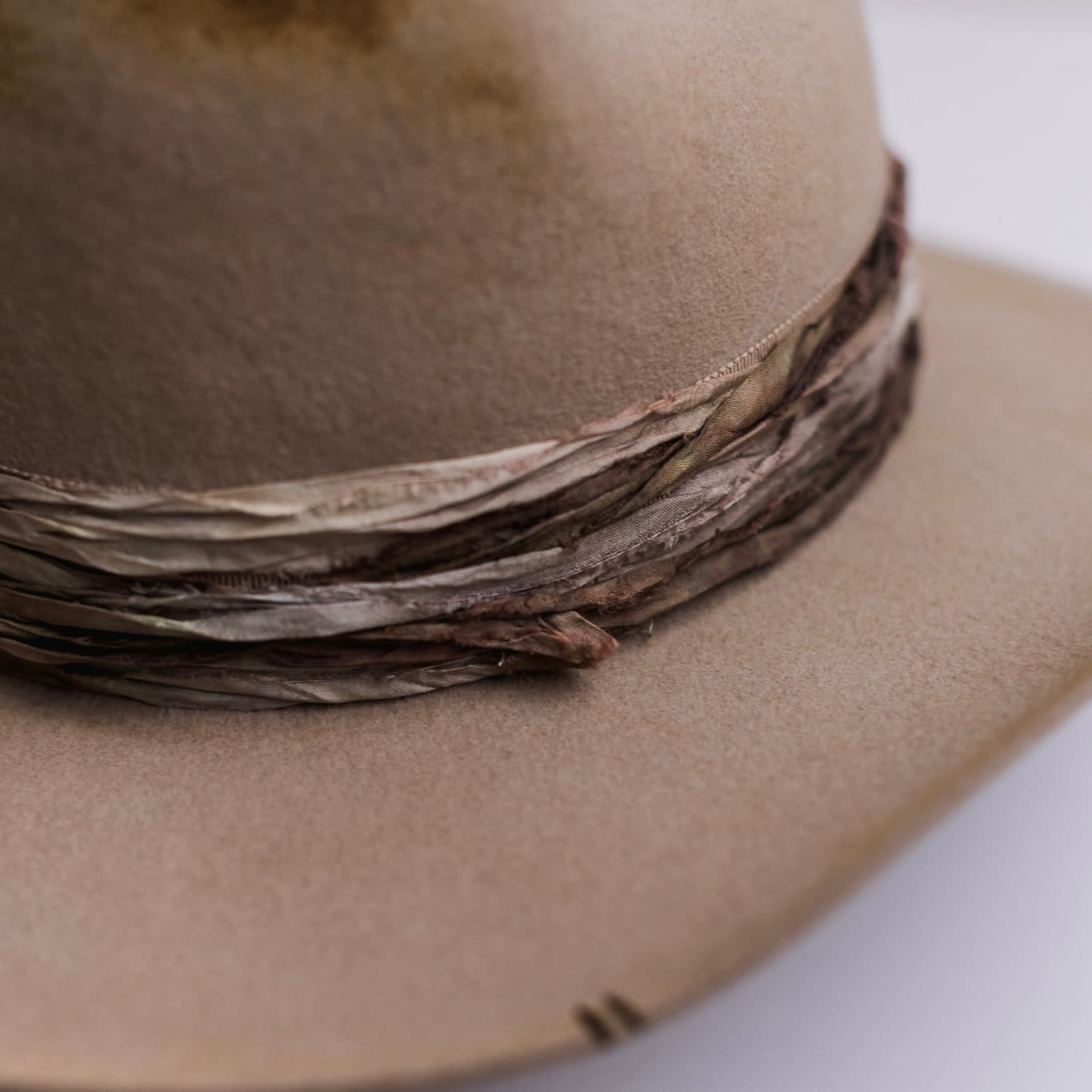 Close up detail of the Wrapped Wheeler Sahara cowboy hat showing layered tonal sari silk band wrapping and brim branding.