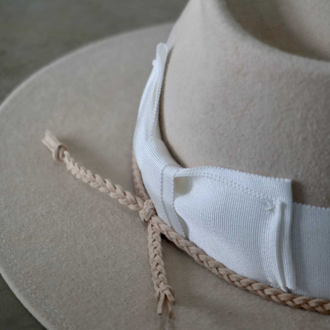 Close up detail of the Yolande felt hat showing nude plaited suede string trim.