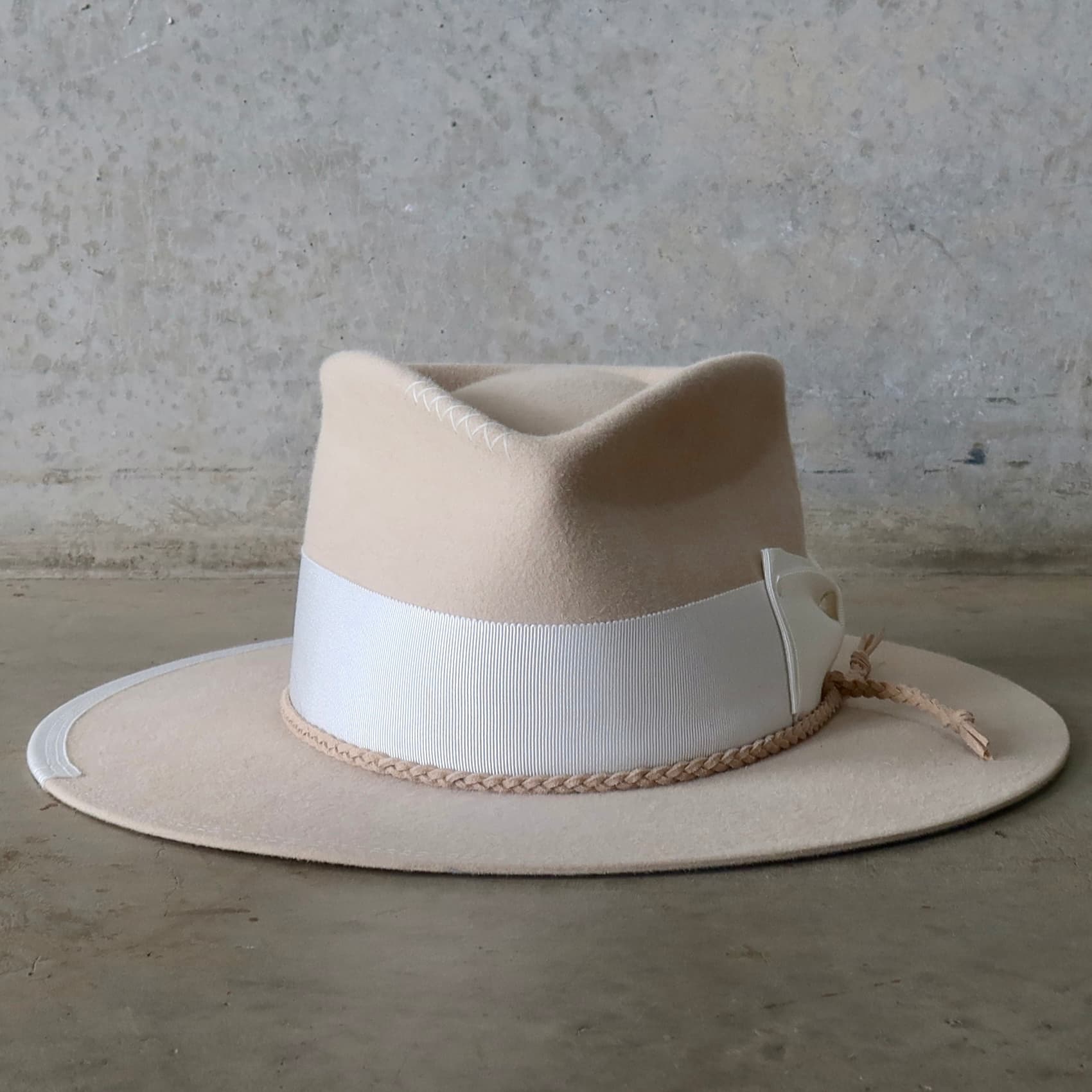 Beige felt hat Yolande by PHYLLi Designs with ivory Japanese grosgrain double bow band and plaited nude suede string.