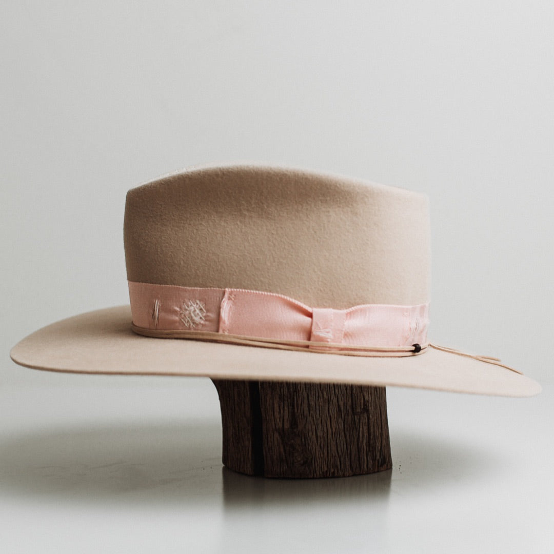 Left side view of the Curlewis beige felt hat by PHYLLi Designs with nude suede string finished with wooden beading.