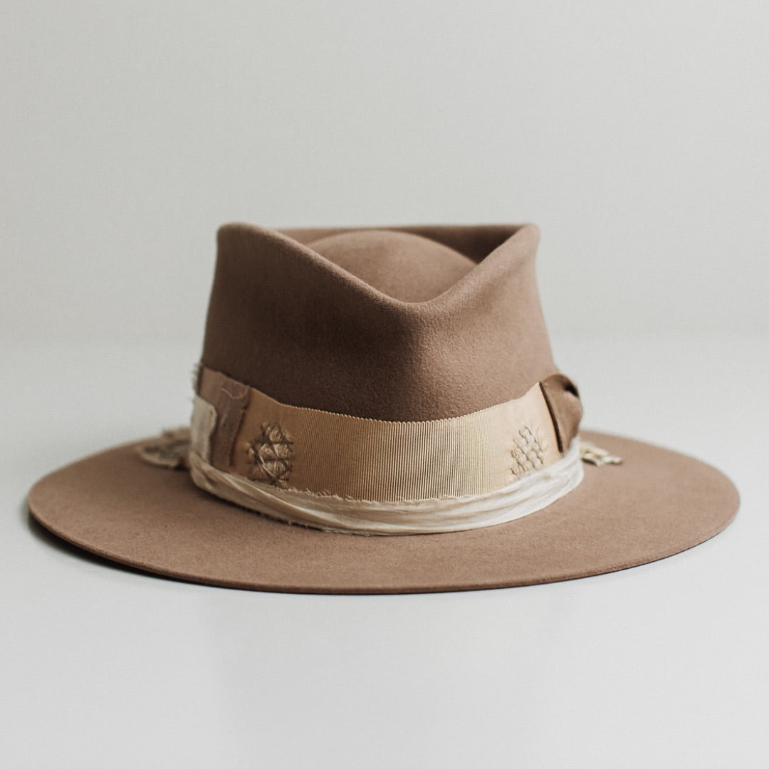 Enso sahara felt hat by PHYLLi Designs with distressed taupe Japanese grosgrain bow band and wabi sabi patch detailing.