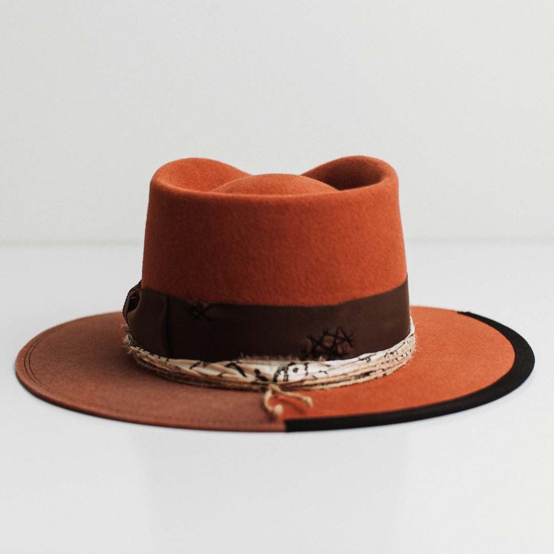 Back view of the Marrakech spiced pumpkin felt hat by PHYLLi Designs featuring distressed grosgrain band with black darned patches.